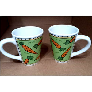 2 Starbucks mugs, green with orange carrots. By Ursala Dodge